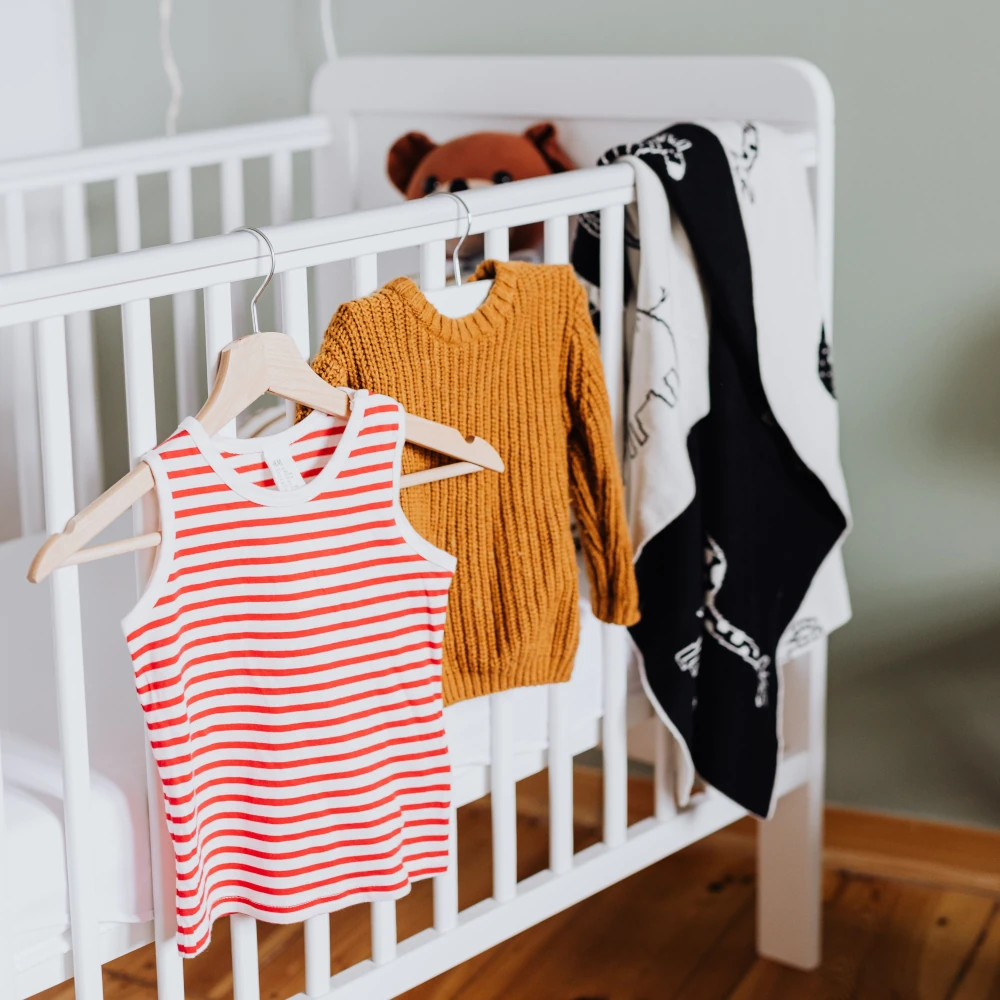 Baby clothes hanging on a crib